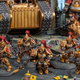 Power armored marines of the Adeptes Custodes defend a tank in a miniature display from Games Workshop's Warhammer 40,000.
